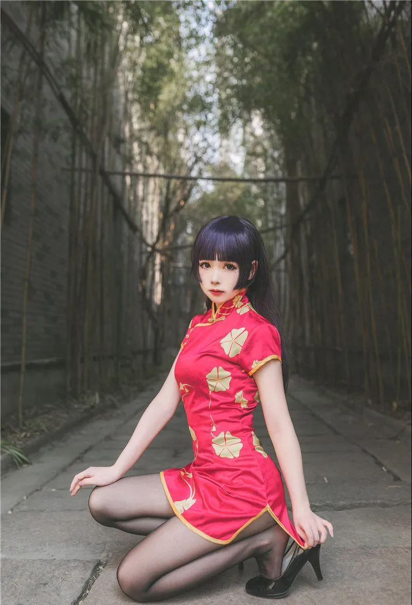 巧克力小圆面包在竹林背景中身着红底金纹旗袍配黑丝，单膝跪地调整高跟鞋，展现古典冷艳风格