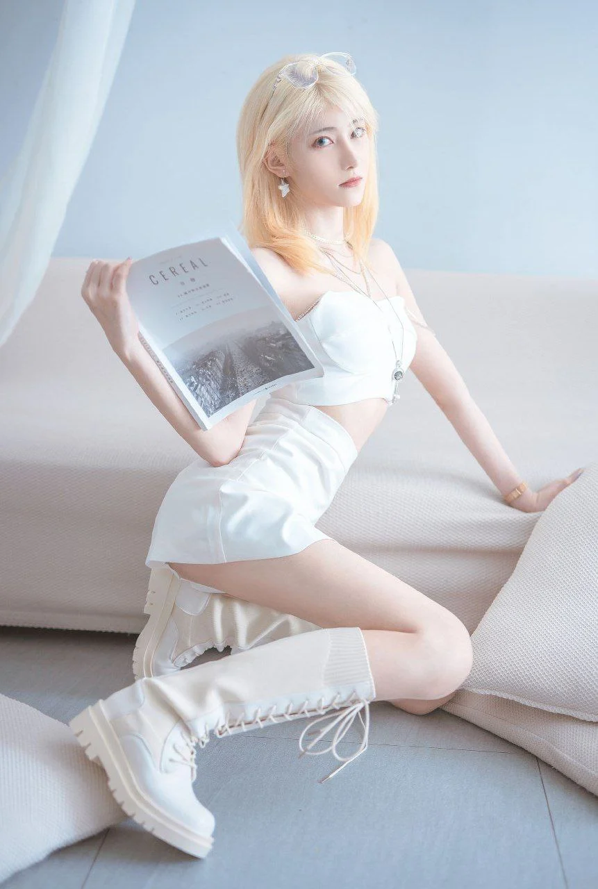 南桃Momoko身穿白色抹胸套装与长靴，在极简风格的纯白室内场景中手持杂志，展现清新纯欲气质