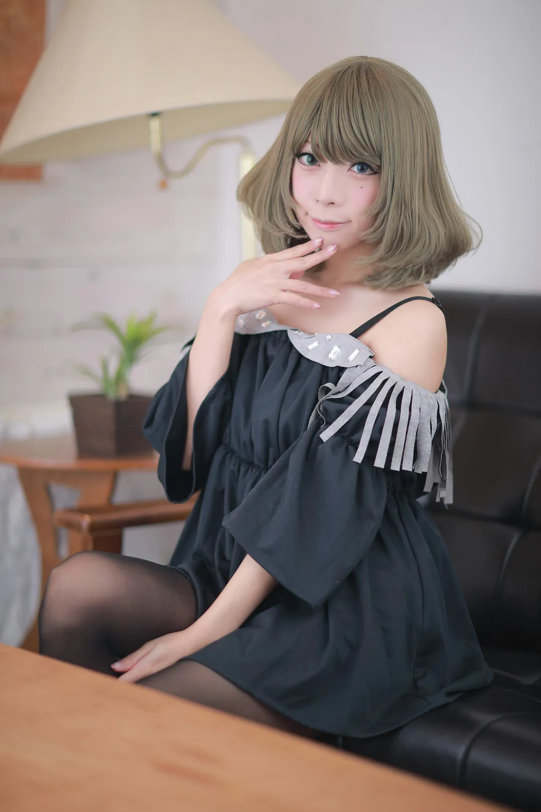宫本彩希短发造型身穿黑色露肩娃娃衫与透肉黑丝，端坐沙发展现居家慵懒的轻熟诱惑
