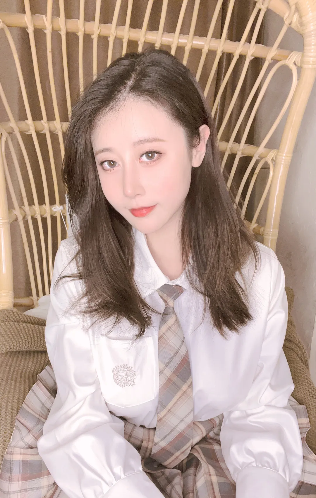 奈汐酱nice在藤椅上穿白衬衫和格纹领带坐着的照片