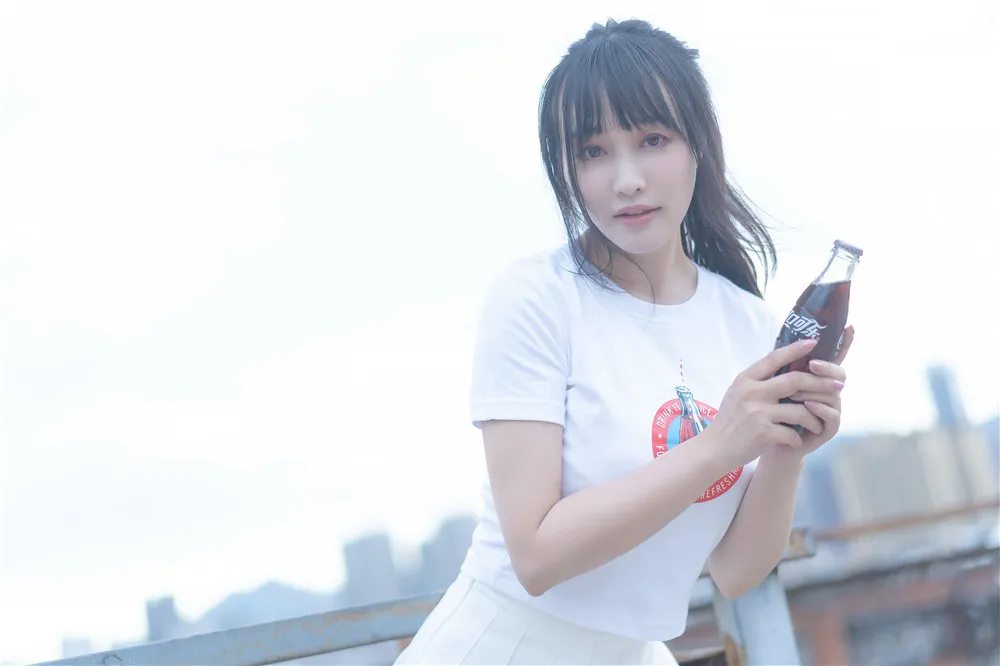 屋顶白色短袖上衣配白裙手拿可乐瓶的站姿图