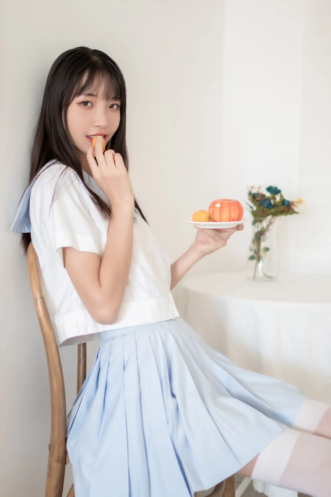 西瓜少女室内蓝裙坐姿吃苹果照片