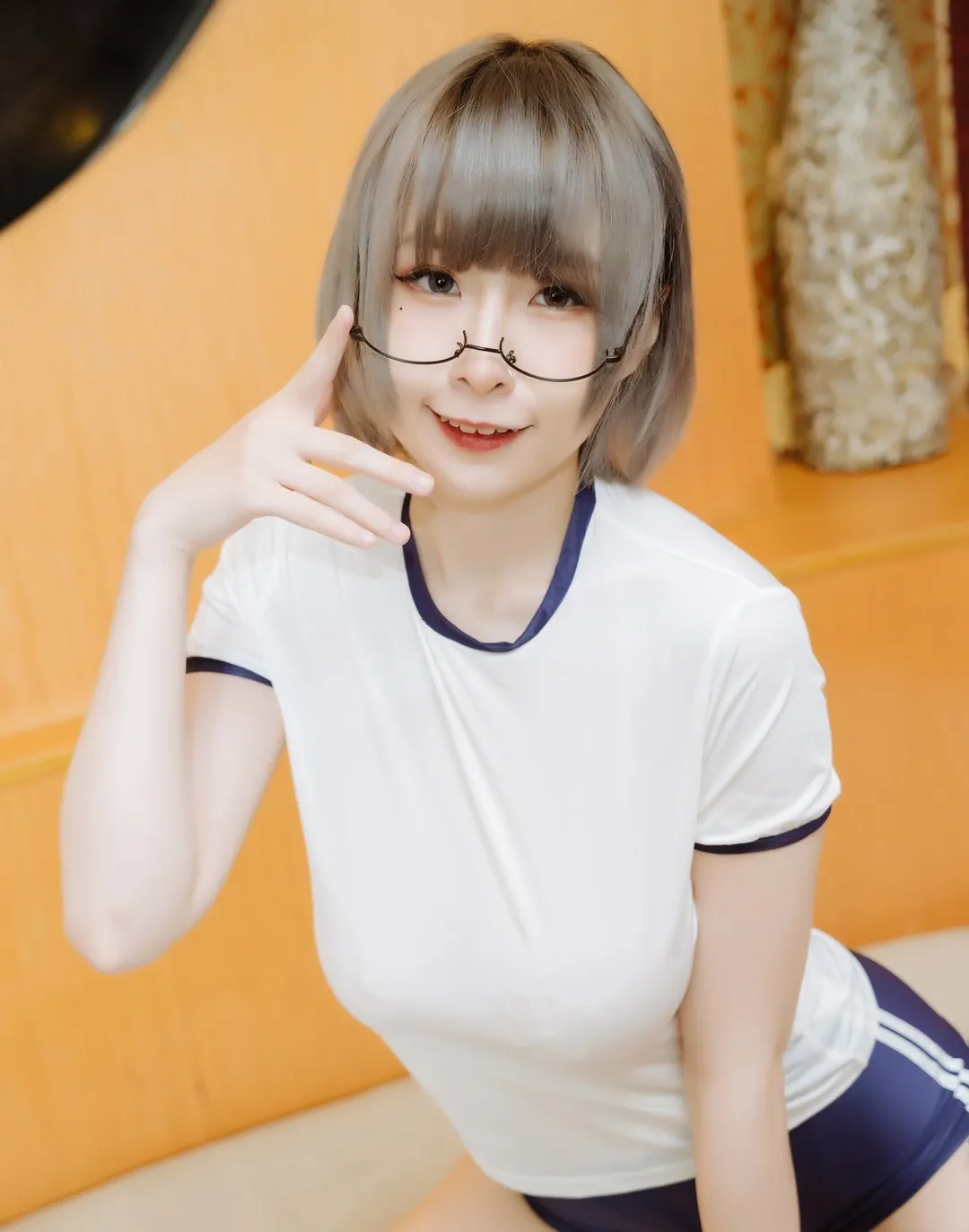 黎菲儿戴圆框眼镜穿白色体操服坐在暖色室内的cos写真