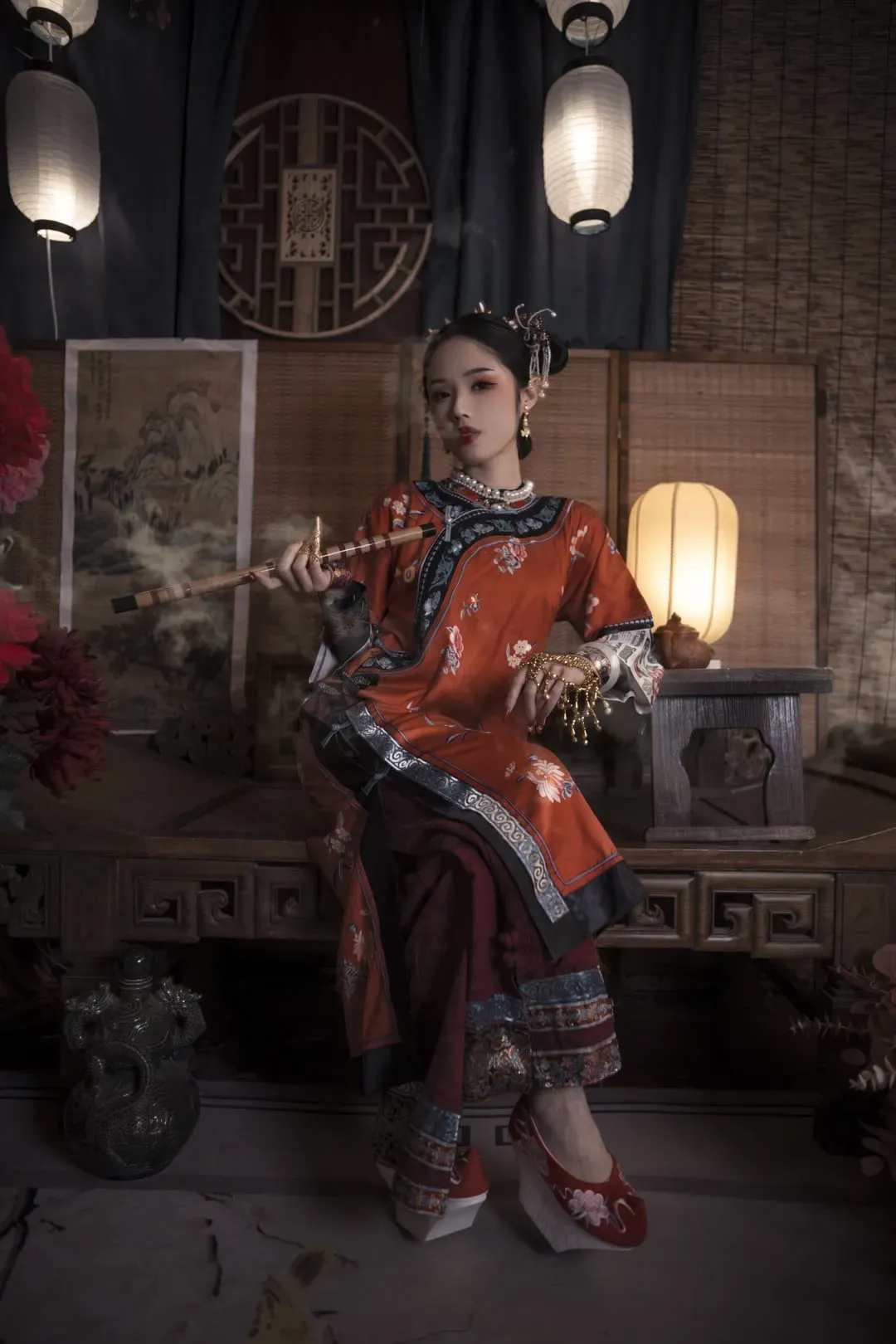 钛合金titi穿红色绣花长衫坐在中式室内木桌上的照片