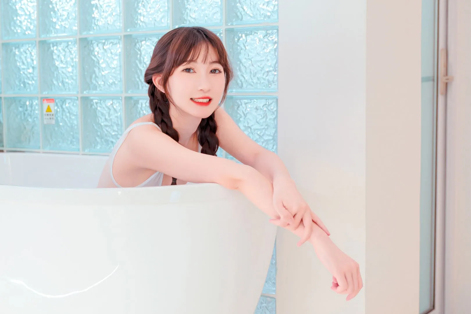 夏树坐在白色浴缸中露出笑容，玻璃砖背景和浅蓝色调很清新