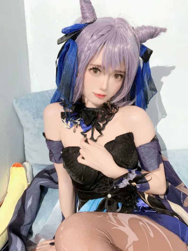 MyungAh紫色长发角状头饰和黑紫服饰坐在浅色背景前