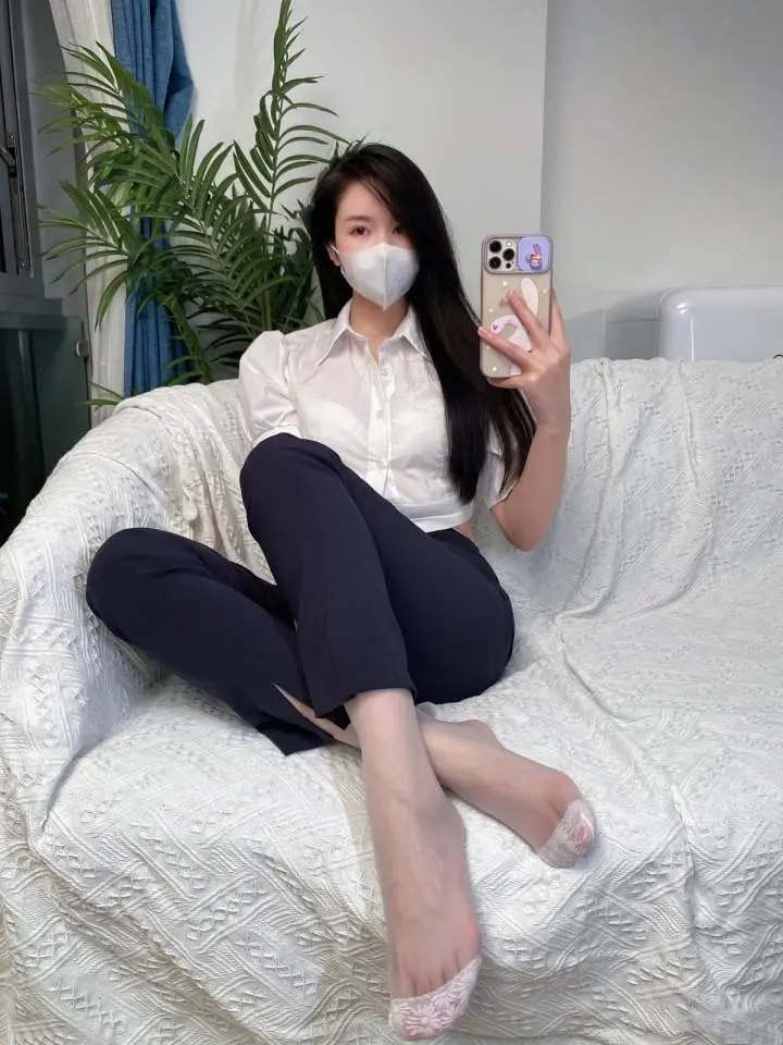 July芝岚白色衬衣黑色长裤坐在白色沙发上手持手机自拍