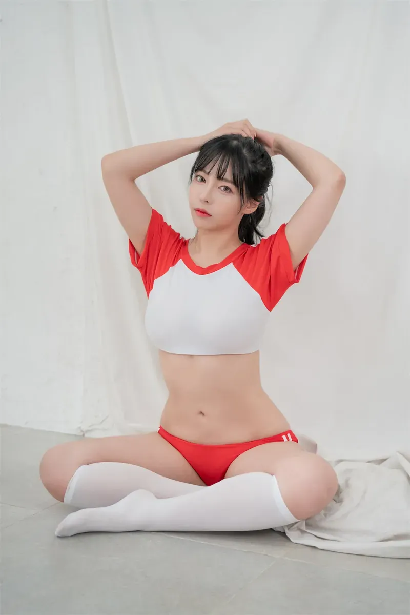 慕慕Momo穿红白运动风服装坐在浅色室内背景前