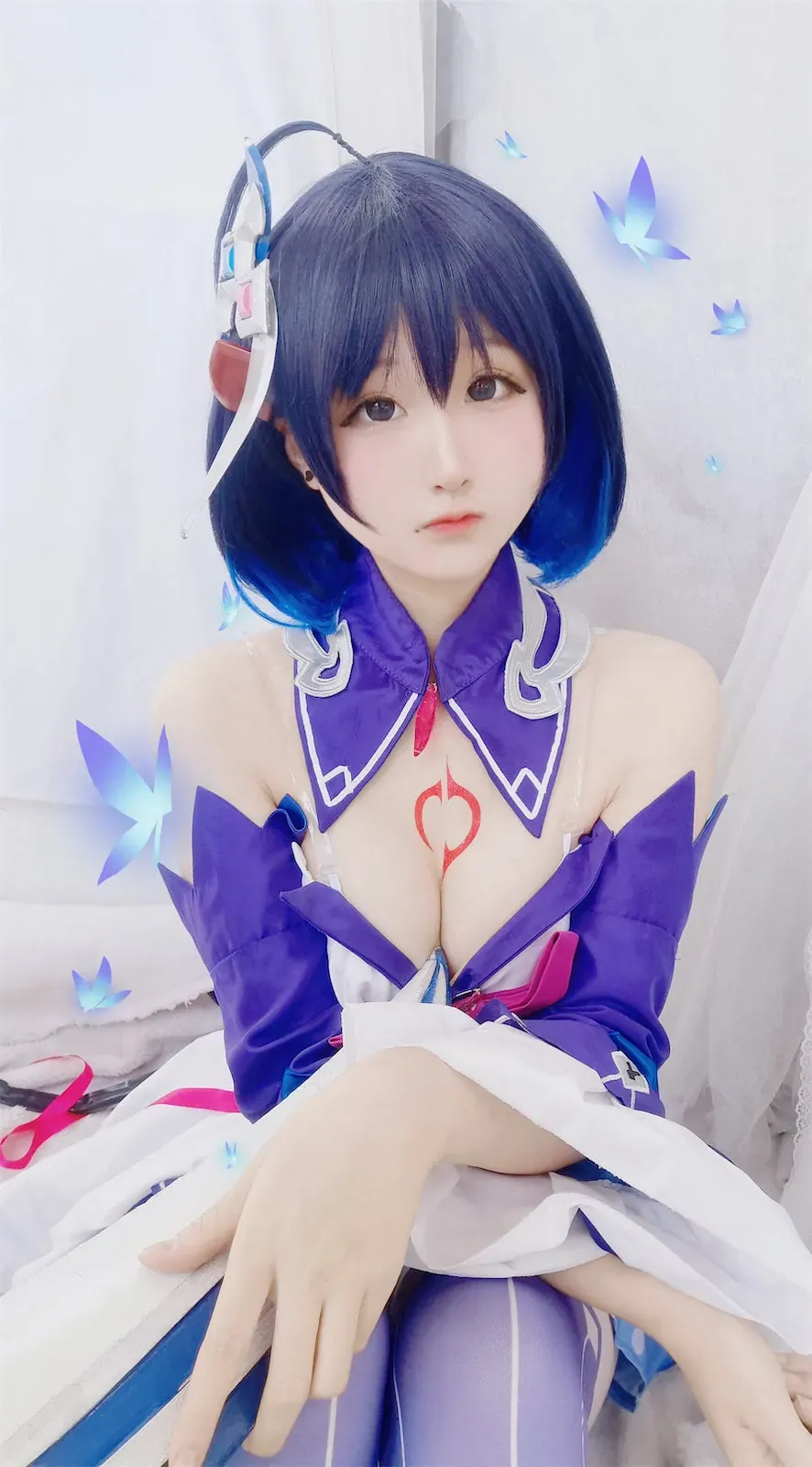 Seele麦麦蓝紫短发穿紫白角色服坐在白色室内背景前