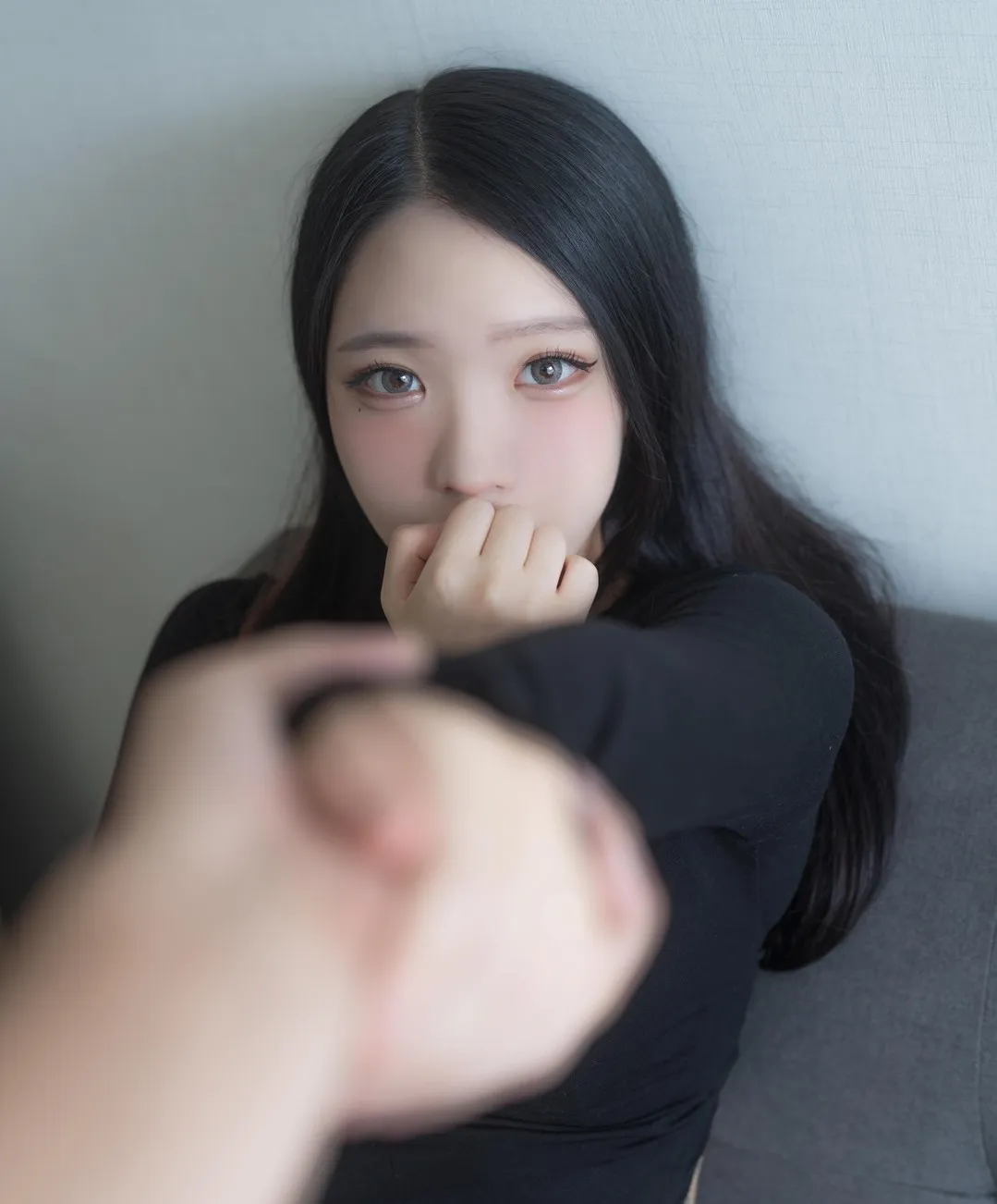 YeonHwa 黑色长发穿黑色上衣坐在灰色室内背景前