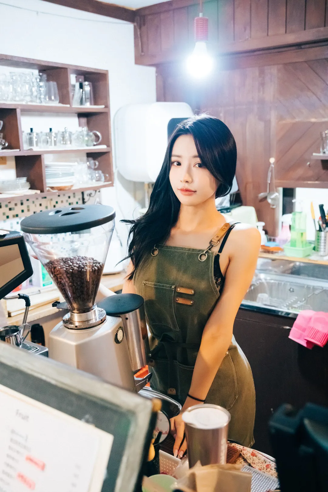 YeonYu 长发橄榄绿色围裙站在咖啡吧台后方