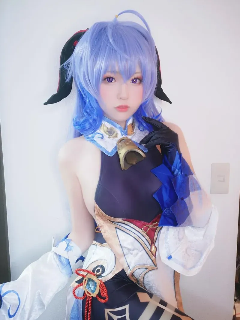 Yuki亭 浅蓝短发黑色耳饰深色角色服站在白墙前