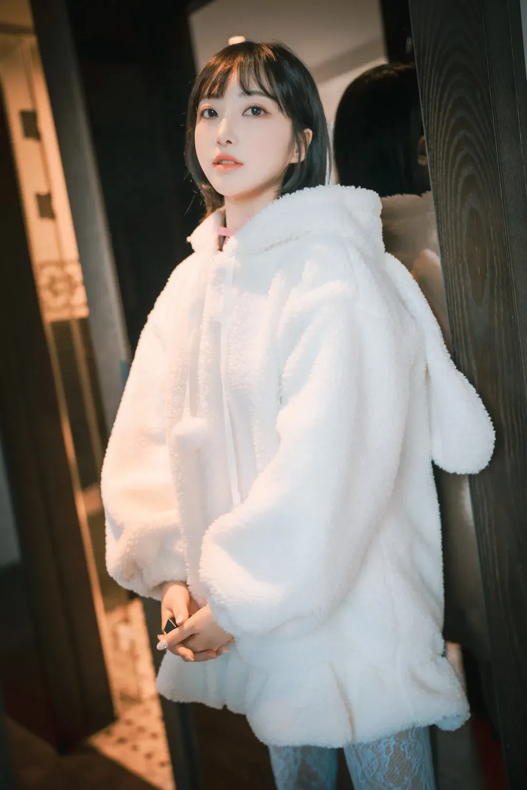 HaNari(하나리)短发刘海，穿白色毛绒连帽外套靠在暗色门边的写真