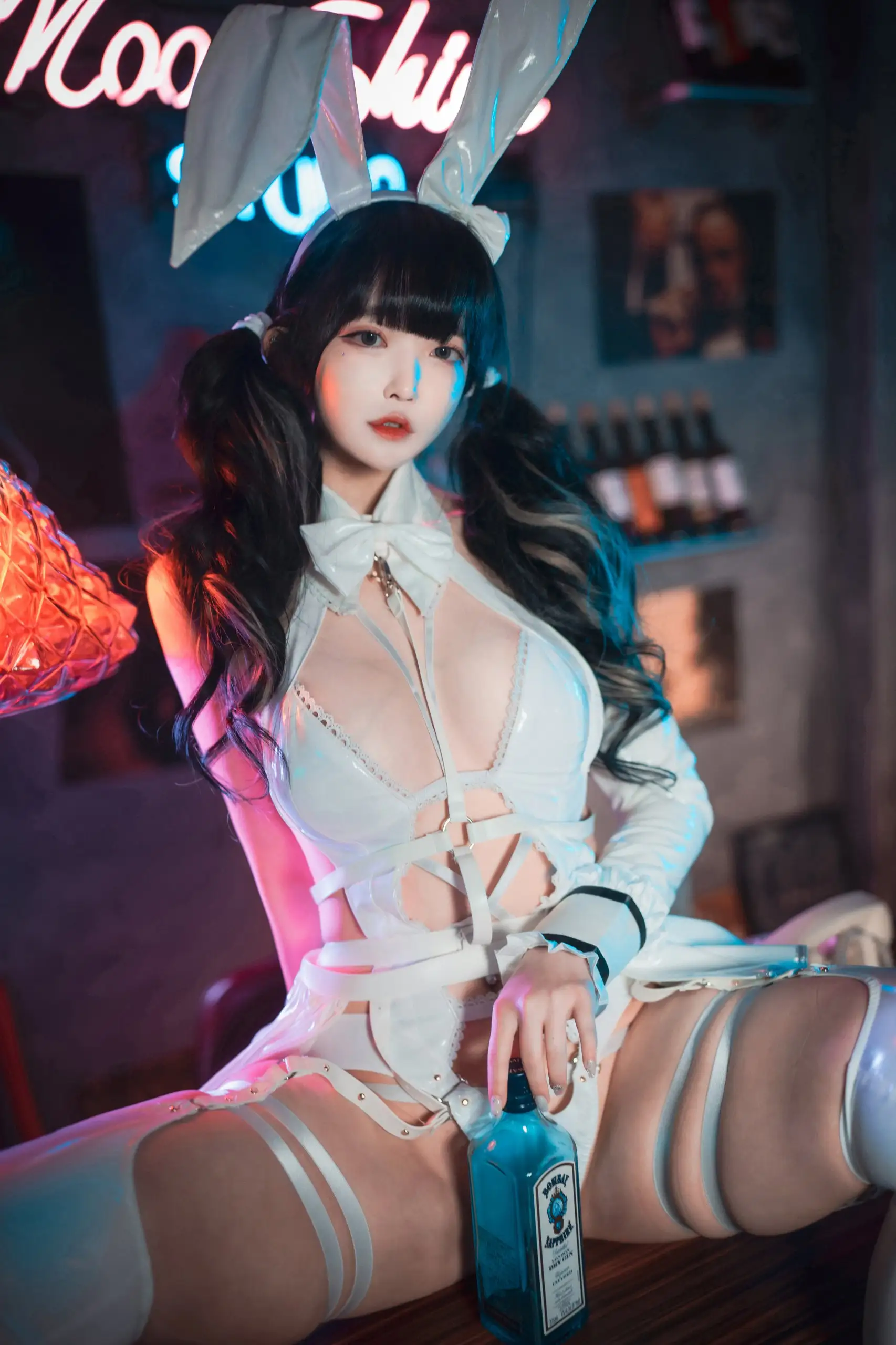 Aram(아람)戴白色兔耳穿白色兔女郎服装坐在霓虹灯背景前手扶蓝色酒瓶