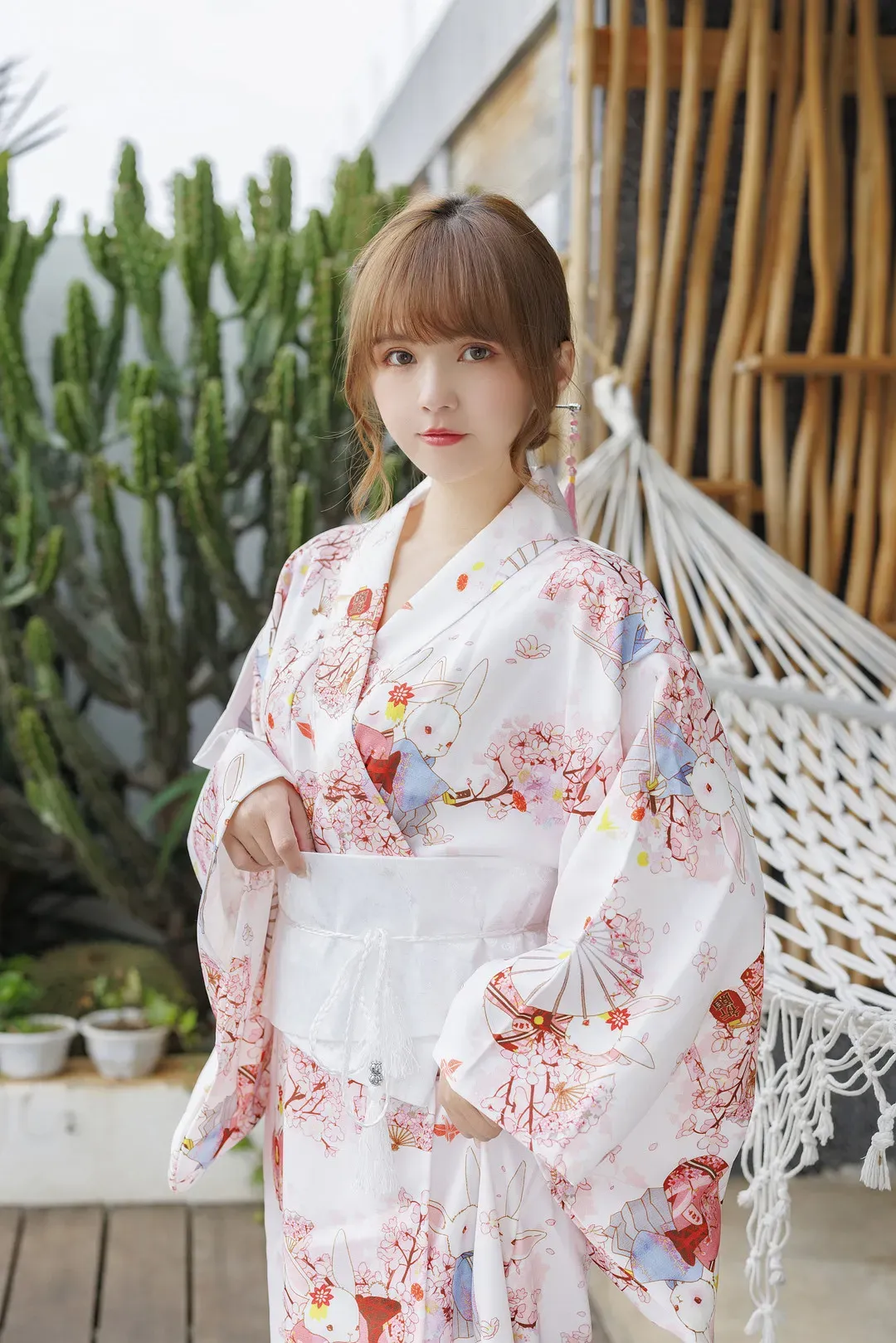 张思允Nice白色花纹和服站在绿植与吊床旁写真
