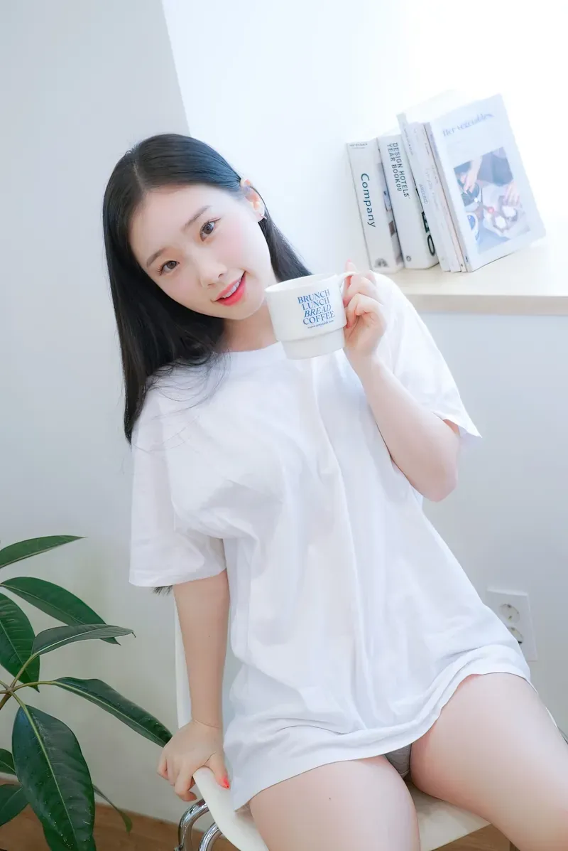 Aery Tiefling穿白色宽松T恤坐在椅子上手持白色杯子的室内写真