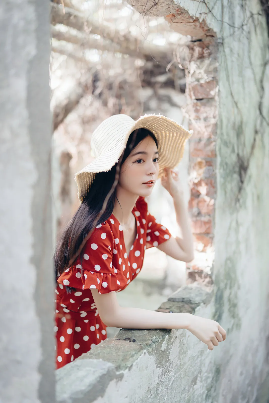 辰辰 穿红色波点裙戴草帽站在旧墙开口旁