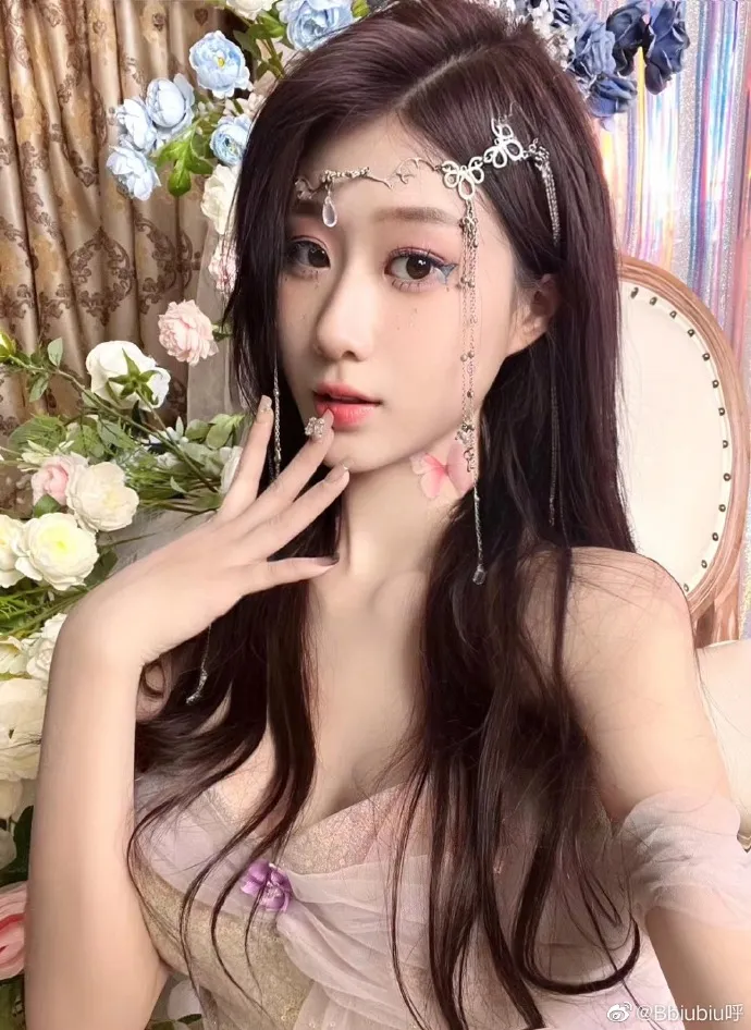 bbiubiu呼 长发戴银色额饰穿浅色纱质服装靠近花艺背景的写真