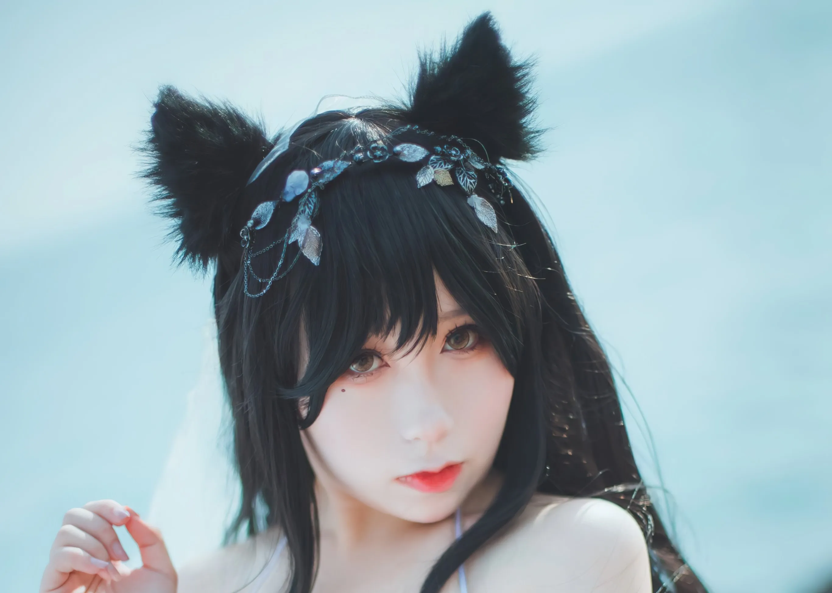 柚子先生黑色长发模特戴黑猫耳和银色头饰在蓝色背景前近景出镜