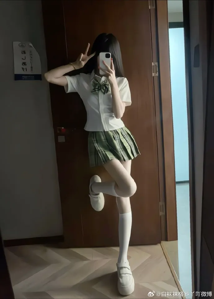 白袜袜格罗丫穿白色短袖衬衫和绿色格裙在门前对镜自拍的写真