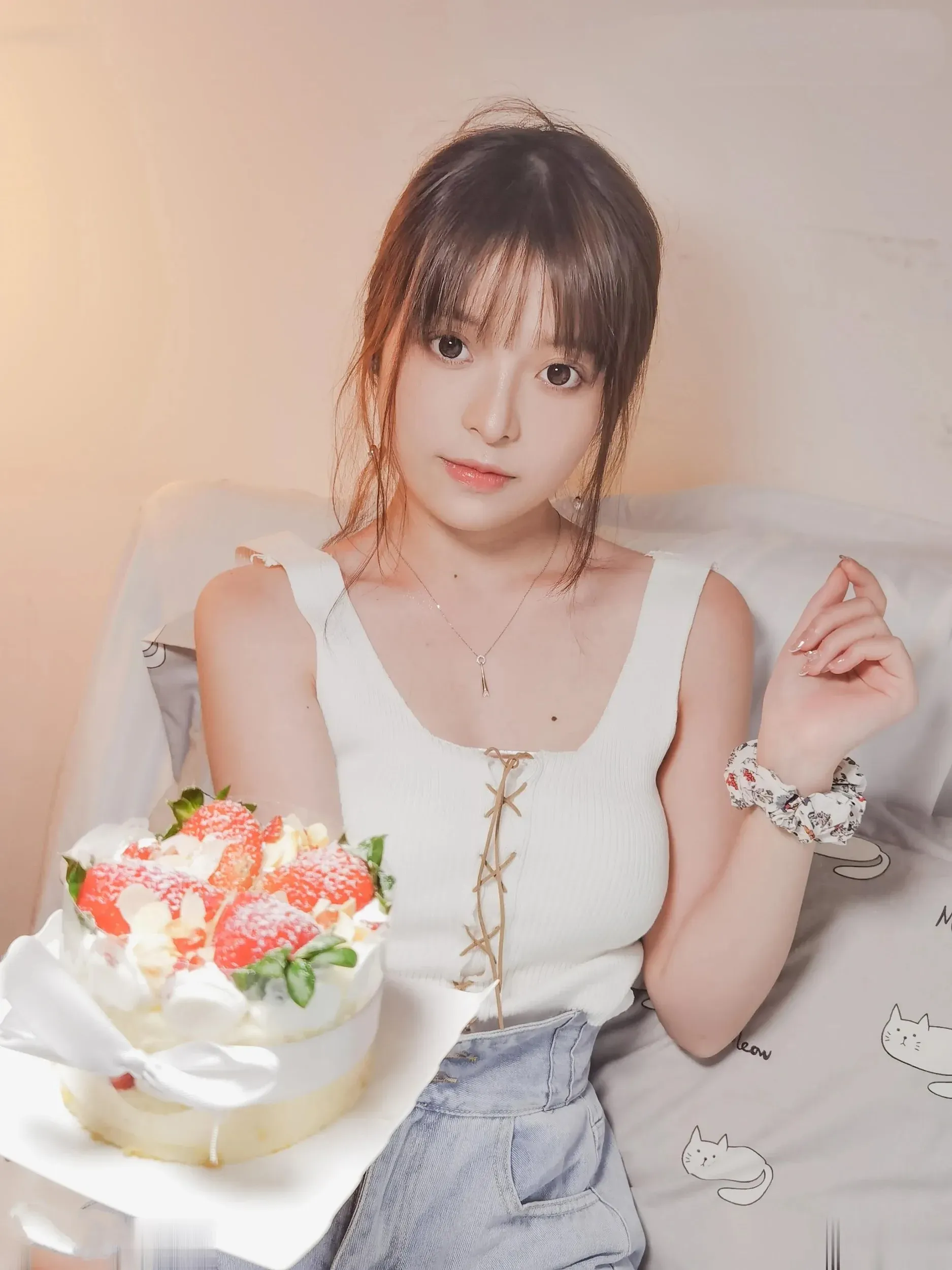 草莓味的奈奈兔穿白色上衣坐在床边拿着草莓蛋糕的写真