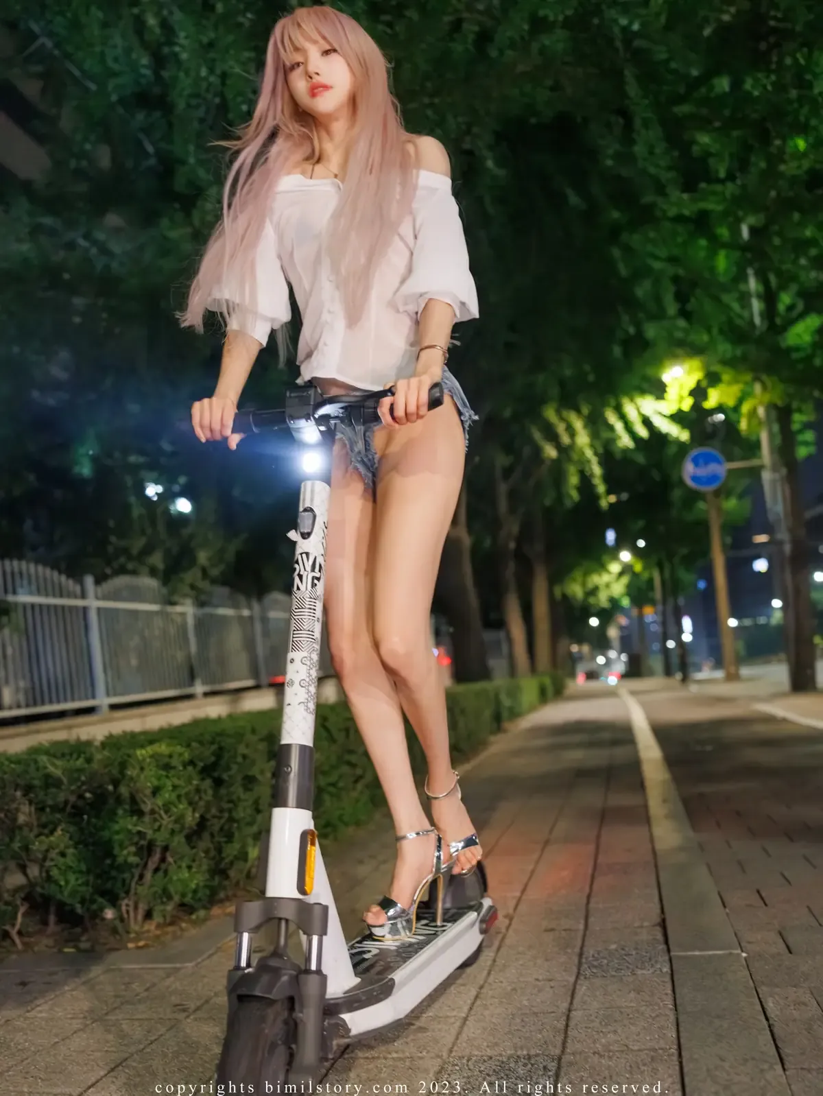 大米米球写真,浅色长发人物站在户外骑行设备旁